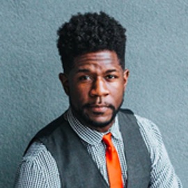 Man with dress shirt, vest and orange tie