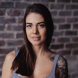 Woman with tank top and tattoos on her left arm of a flower